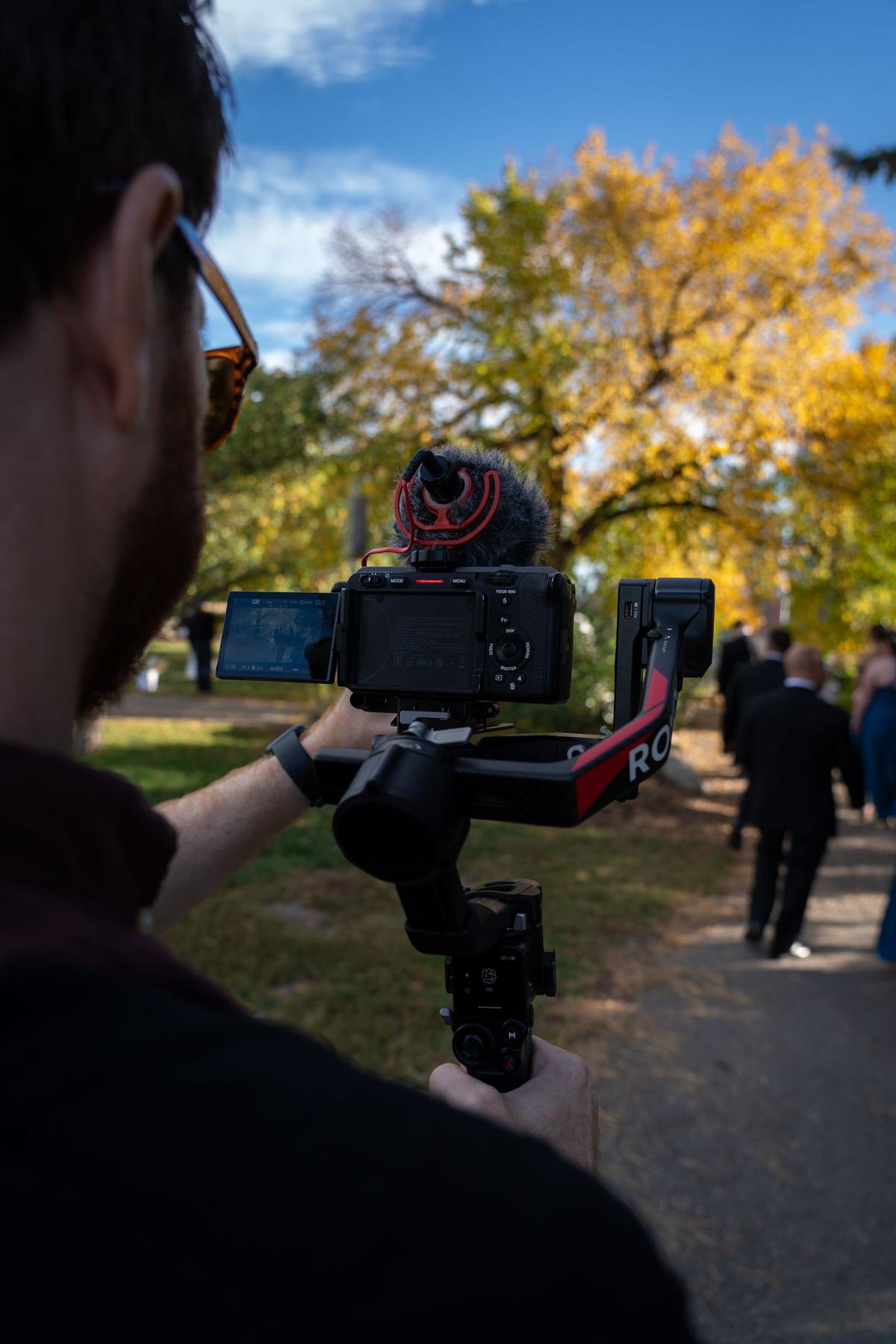Videograf som filmer et bryllup utendørs om høsten