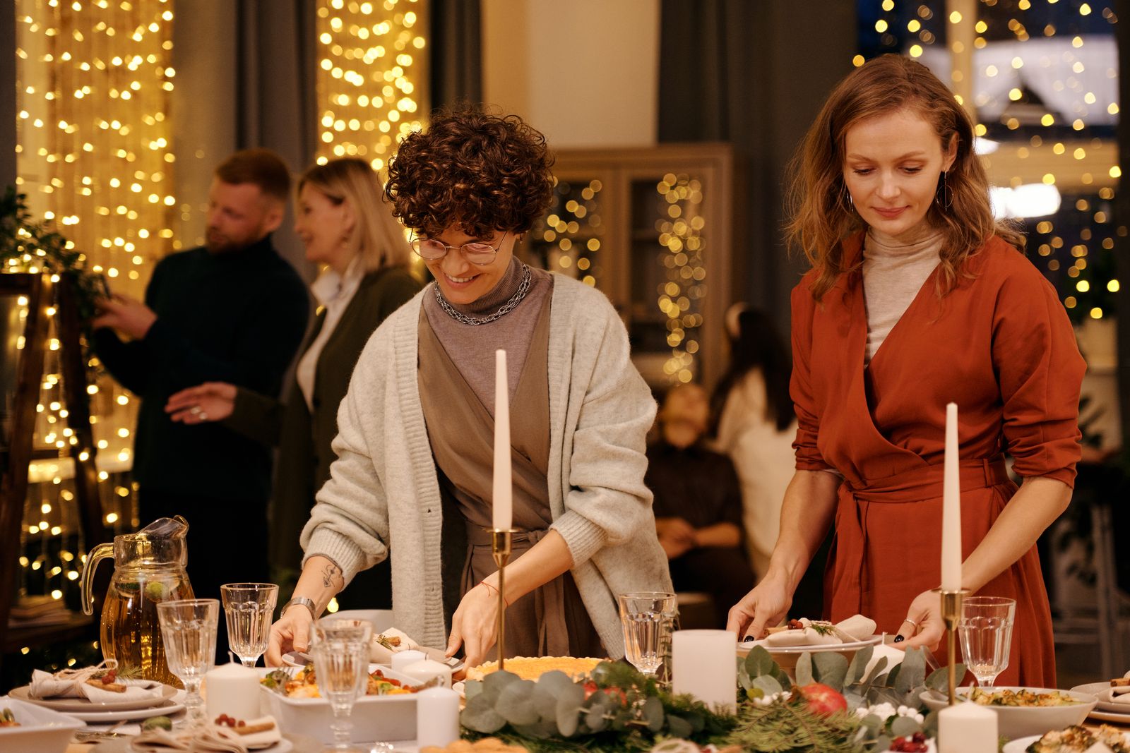 To personer dekker et bord til julemiddag