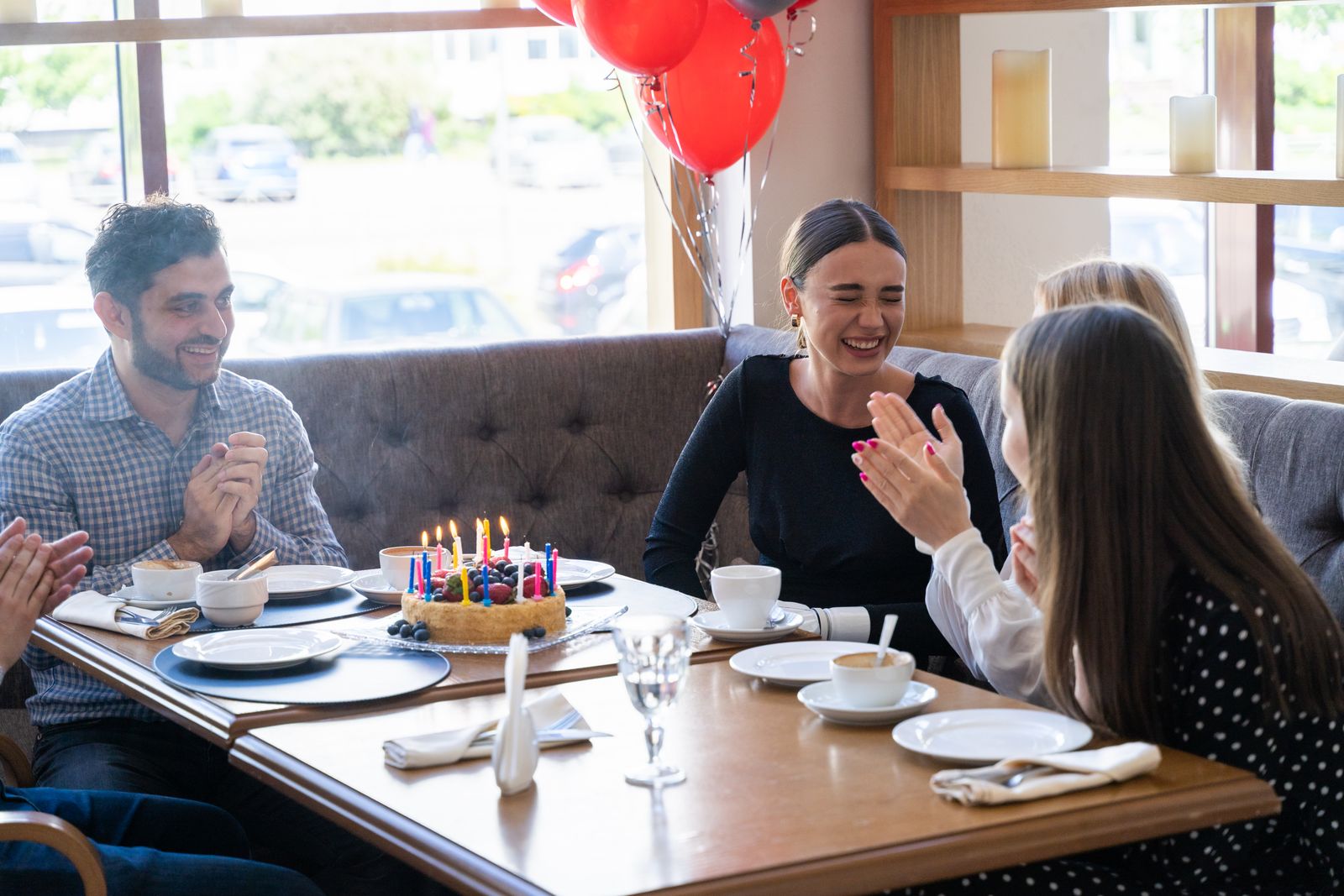 Venner som feirer med kake rundt et bord